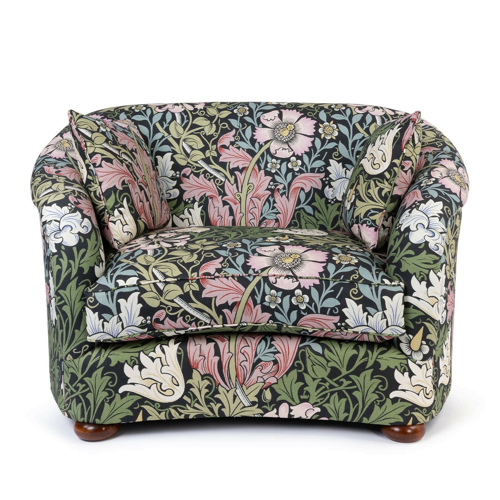 A Vesper Loveseat with a floral pattern in a mix of green, pink, and other colors on a black background, featuring sloping arms and a continuous curved backrest, with a pair of matching scatter cushions,  available  to buy on the-salon.com. SALON curates the finest , unique, handmade pieces from the interior industry's best makers and brands. Shop luxury furniture, lighting, rugs, art, antiques and vintage pieces and accessories from SALON interior designed rooms.