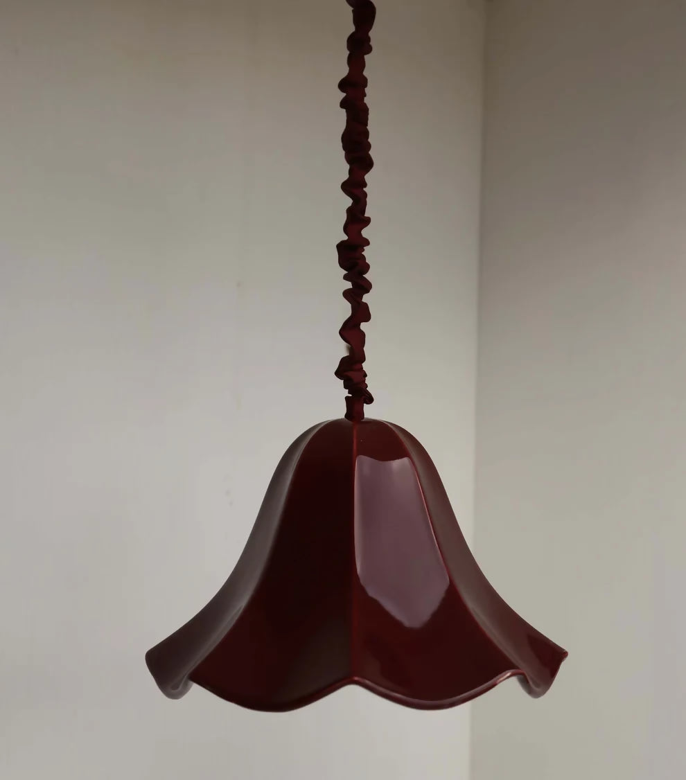 A red, conical pendant light with a glossy finish and a silk satin cord cover,  available  to buy on the-salon.com. SALON curates the finest , unique, handmade pieces from the interior industry's best makers and brands. Shop luxury furniture, lighting, rugs, art, antiques and vintage pieces and accessories from SALON interior designed rooms.