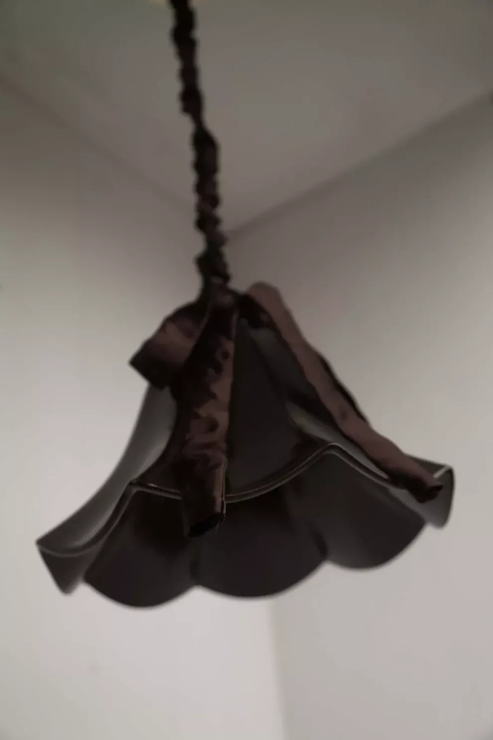 A brown, conical pendant light with a glossy finish and a silk satin cord cover,  available  to buy on the-salon.com. SALON curates the finest , unique, handmade pieces from the interior industry's best makers and brands. Shop luxury furniture, lighting, rugs, art, antiques and vintage pieces and accessories from SALON interior designed rooms.