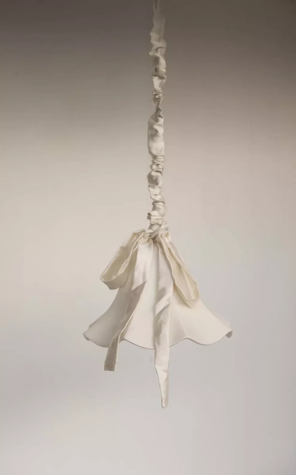 A white, conical pendant light with a glossy finish and a silk satin cord cover,  available  to buy on the-salon.com. SALON curates the finest , unique, handmade pieces from the interior industry's best makers and brands. Shop luxury furniture, lighting, rugs, art, antiques and vintage pieces and accessories from SALON interior designed rooms.