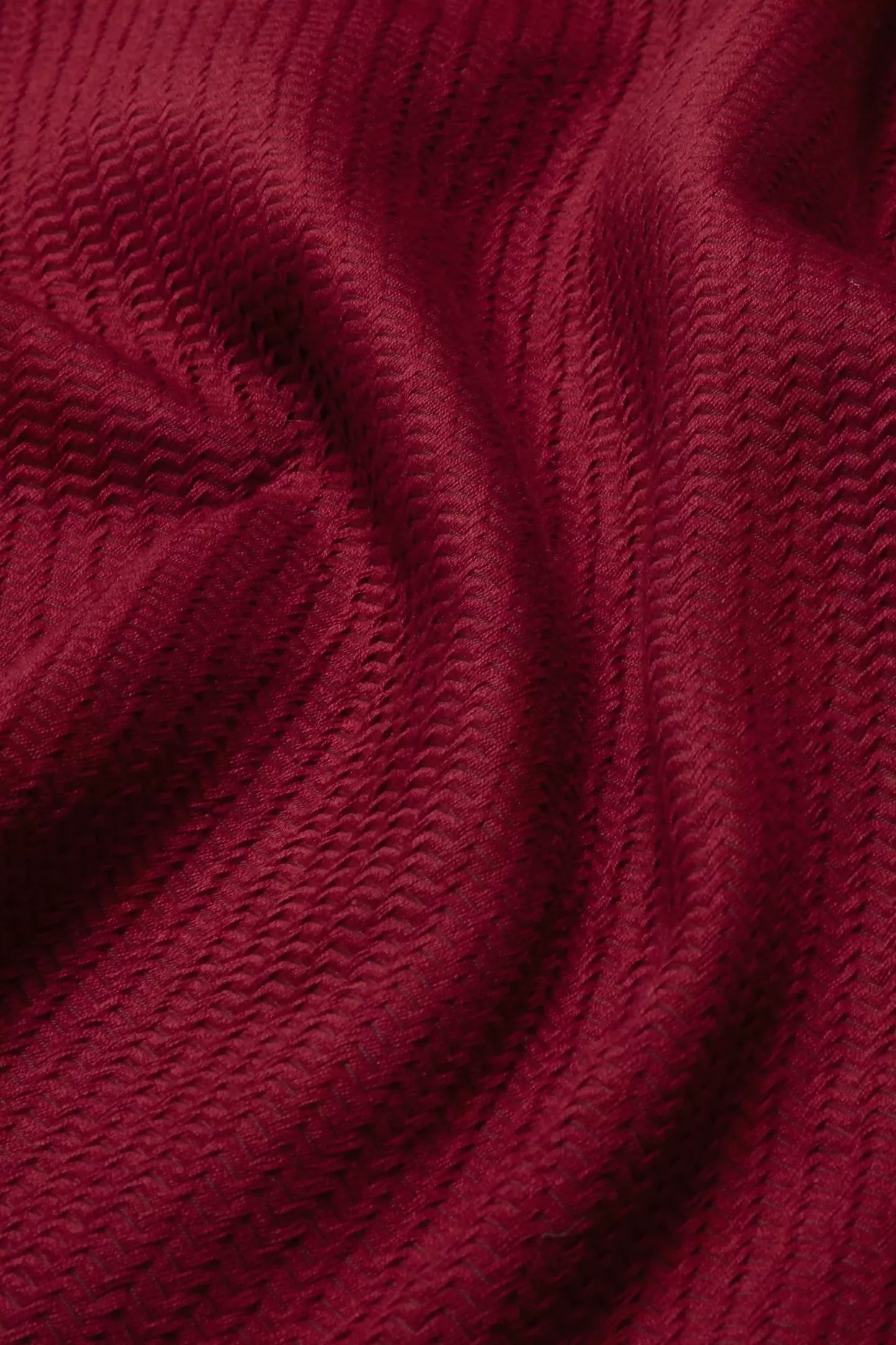 Close-up view of a red fabric with a textured weave pattern suitable for upholstery,  available  to buy on the-salon.com. SALON curates the finest , unique, handmade pieces from the interior industry's best makers and brands. Shop luxury furniture, lighting, rugs, art, antiques and vintage pieces and accessories from SALON interior designed rooms.