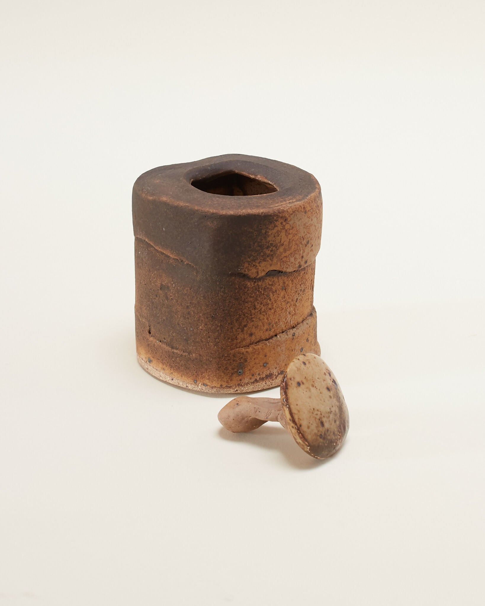 Bronze-colored cylindrical box with an opening on a white background,  available  to buy on the-salon.com. SALON curates the finest , unique, handmade pieces from the interior industry's best makers and brands. Shop luxury furniture, lighting, rugs, art, antiques and vintage pieces and accessories from SALON interior designed rooms.
