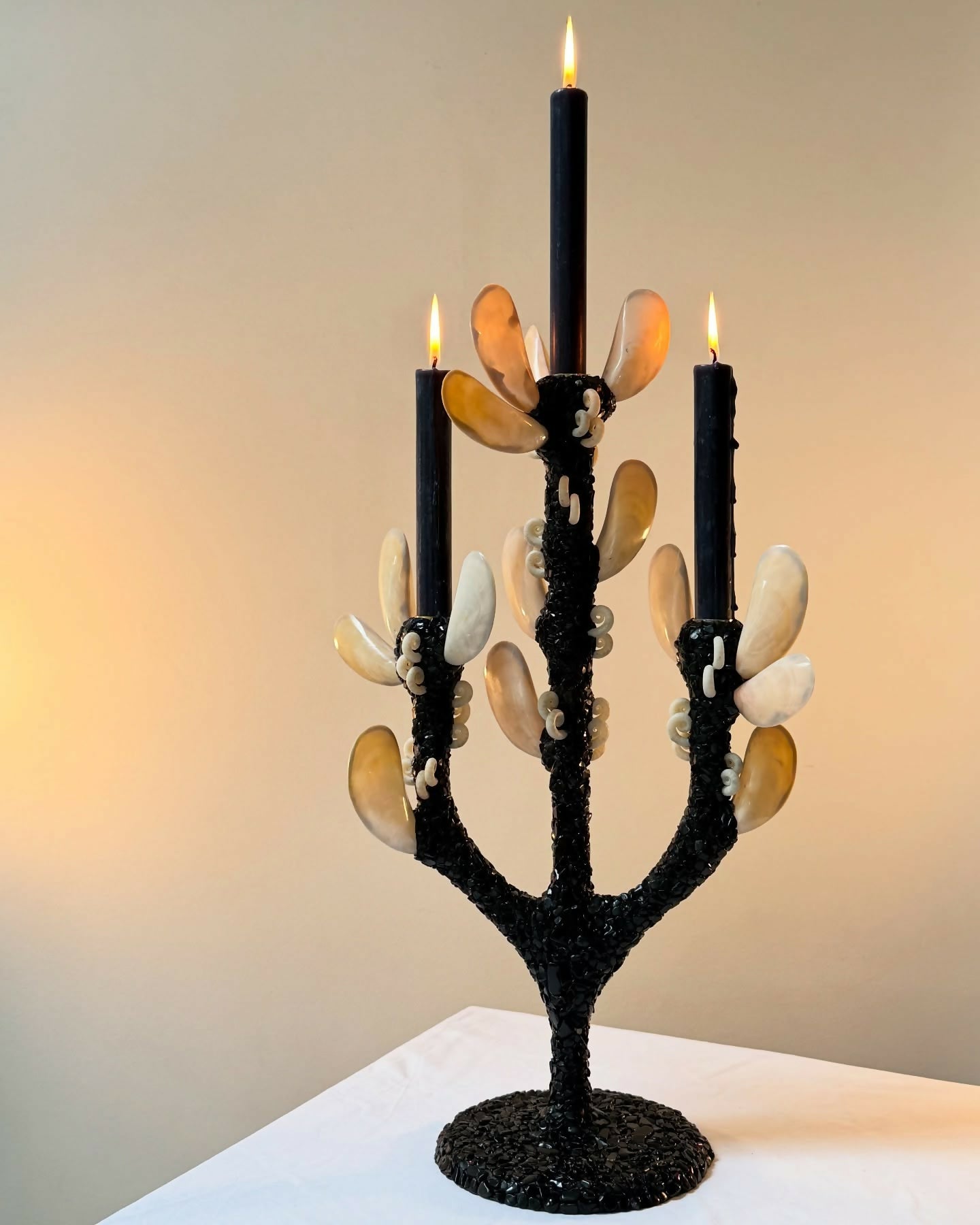 Candle holder with black base and decorative elements on a white surface,available to buy from the-salon.com. SALON curates the finest unique handmade pieces from the interior industry's best makers and brands. Shop luxury furniture, lighting, rugs, art, antiques and vintage pieces and accessories from SALON interior designed rooms.