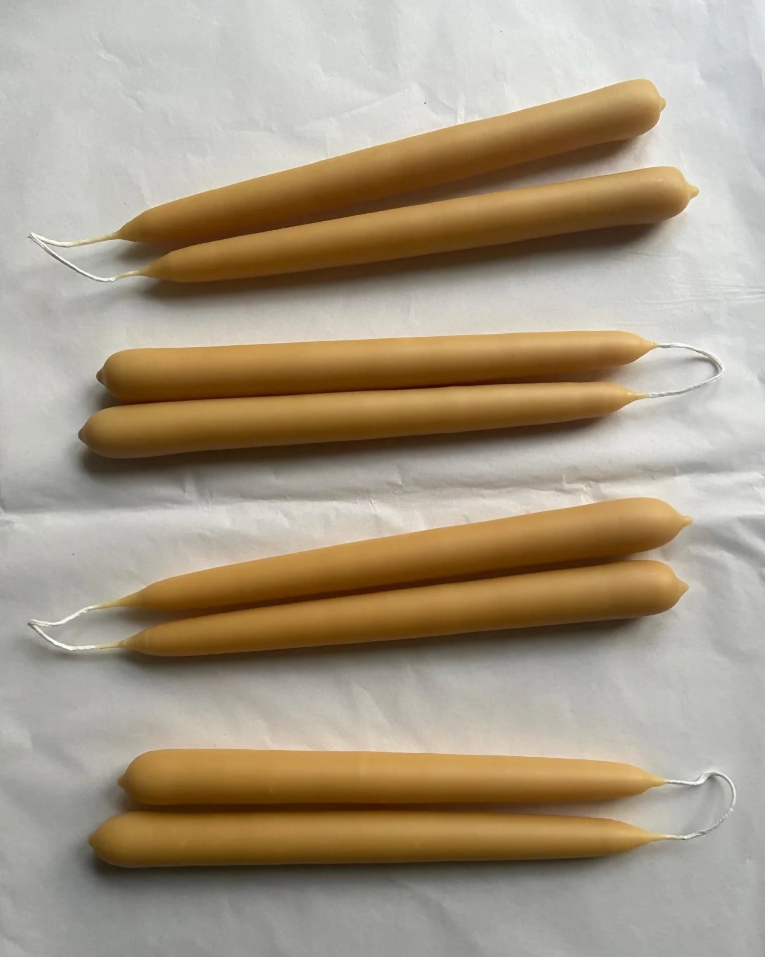 Set of six beeswax candles on a white background