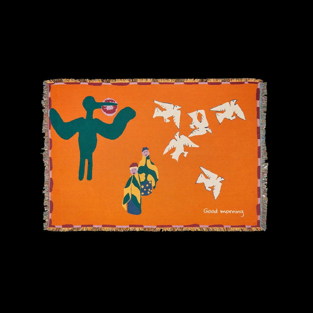 A colourful throw blanket featuring an illustration of a bird, an ostrich, and a jackal in a whimsical morning scene with the text 'Good morning' at the bottom,  available  to buy on the-salon.com. SALON curates the finest , unique, handmade pieces from the interior industry's best makers and brands. Shop luxury furniture, lighting, rugs, art, antiques and vintage pieces and accessories from SALON interior designed rooms.