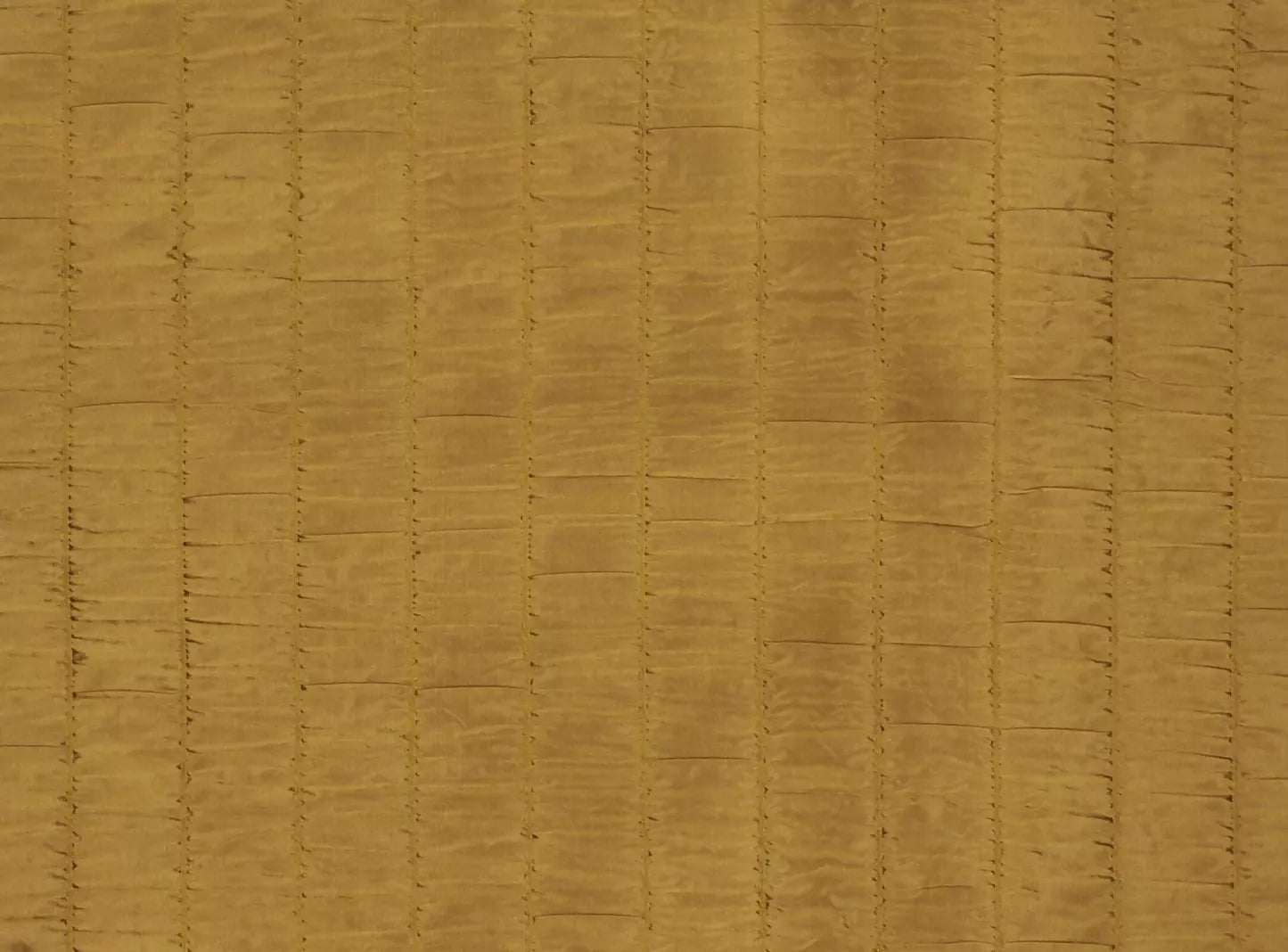 Close-up texture of a bronze-colored silk fabric with detailed stitching,  available  to buy on the-salon.com. SALON curates the finest , unique, handmade pieces from the interior industry's best makers and brands. Shop luxury furniture, lighting, rugs, art, antiques and vintage pieces and accessories from SALON interior designed rooms.