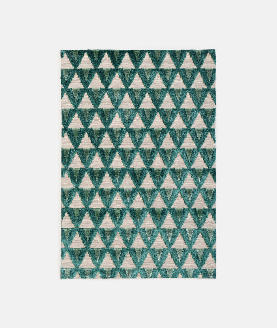 Patterned fabric with teal and blue triangles on a white backdrop,available  to buy on the-salon.com. SALON curates the finest , unique, handmade pieces from the interior industry's best makers and brands. Shop luxury furniture, lighting, rugs, art, antiques and vintage pieces and accessories from SALON interior designed rooms