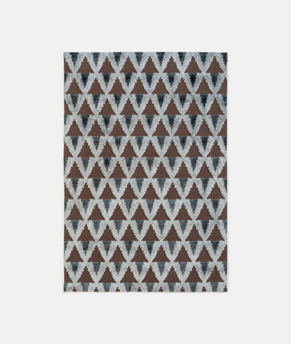 Rug with a geometric triangle pattern on a white background,available  to buy on the-salon.com. SALON curates the finest , unique, handmade pieces from the interior industry's best makers and brands. Shop luxury furniture, lighting, rugs, art, antiques and vintage pieces and accessories from SALON interior designed rooms