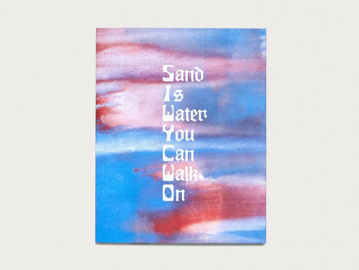 Cover of the book 'SAND IS WATER YOU CAN WALK ON' with abstract painting in blue and red shades, available  to buy on the-salon.com. SALON curates the finest , unique, handmade pieces from the interior industry's best makers and brands. Shop luxury furniture, lighting, rugs, art, antiques and vintage pieces and accessories from SALON interior designed rooms.