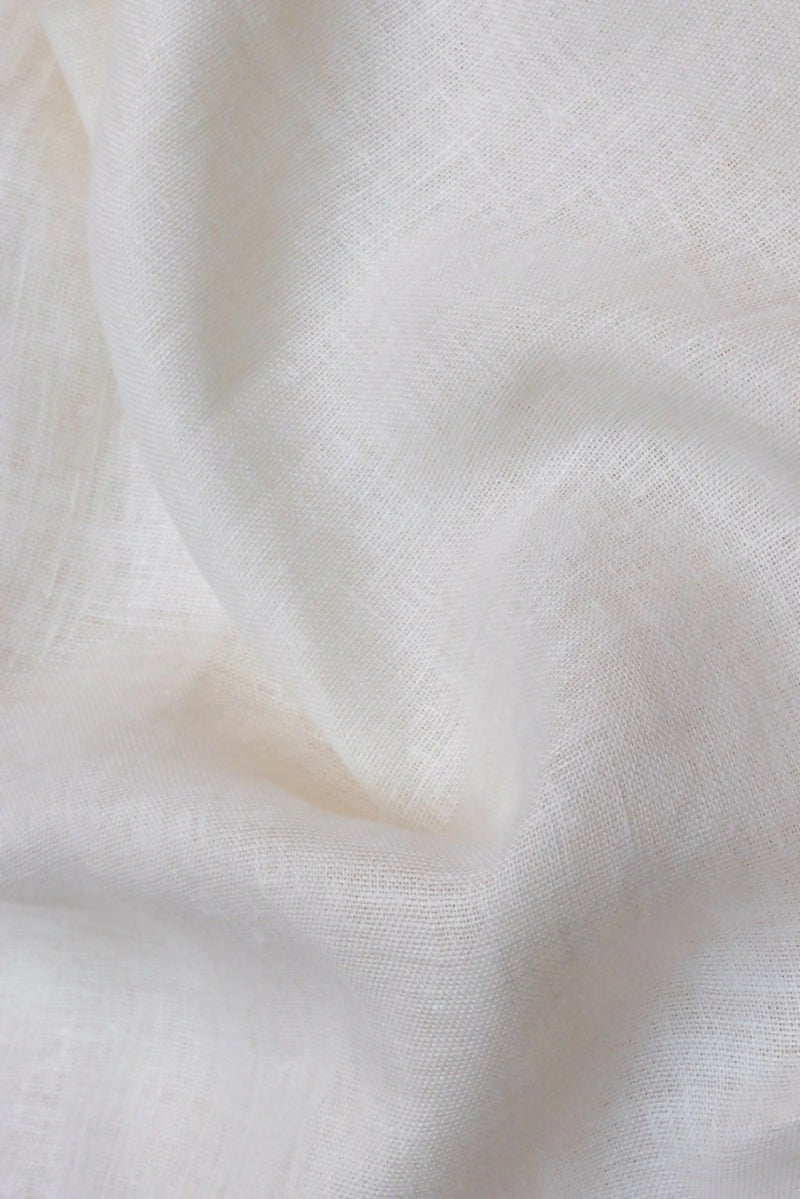 A close-up image of a textured white fabric with a subtle weave pattern, available  to buy on the-salon.com. SALON curates the finest , unique, handmade pieces from the interior industry's best makers and brands. Shop luxury furniture, lighting, rugs, art, antiques and vintage pieces and accessories from SALON interior designed rooms.