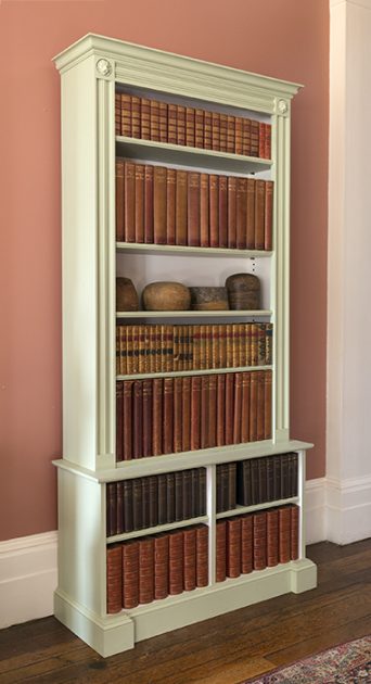 An image of a tall white bookcase, with vintage books inside ,  available  to buy on the-salon.com. SALON curates the finest , unique, handmade pieces from the interior industry's best makers and brands. Shop luxury furniture, lighting, rugs, art, antiques and vintage pieces and accessories from SALON interior designed rooms.