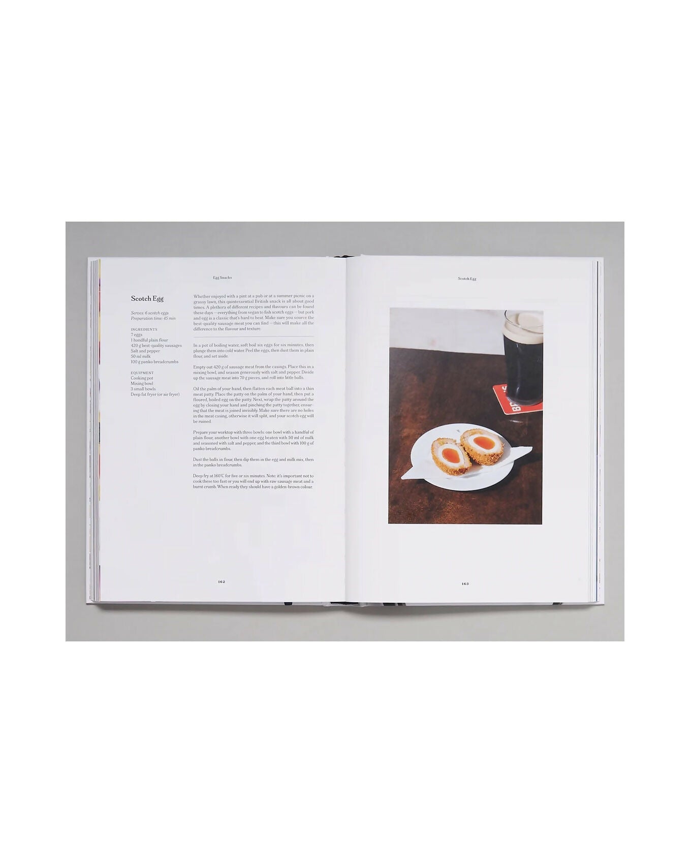 Open book with text and a photograph of food on a white background and a recipe for scotch eggs, available  to buy on the-salon.com. SALON curates the finest , unique, handmade pieces from the interior industry's best makers and brands. Shop luxury furniture, lighting, rugs, art, antiques and vintage pieces and accessories from SALON interior designed rooms.