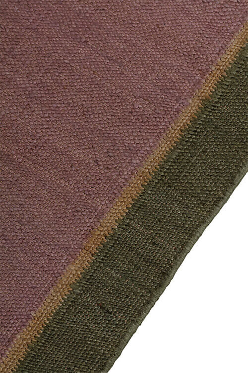 Close-up view of a hand-woven dhurrie rug with a plain texture and a visible border, available  to buy on the-salon.com. SALON curates the finest , unique, handmade pieces from the interior industry's best makers and brands. Shop luxury furniture, lighting, rugs, art, antiques and vintage pieces and accessories from SALON interior d