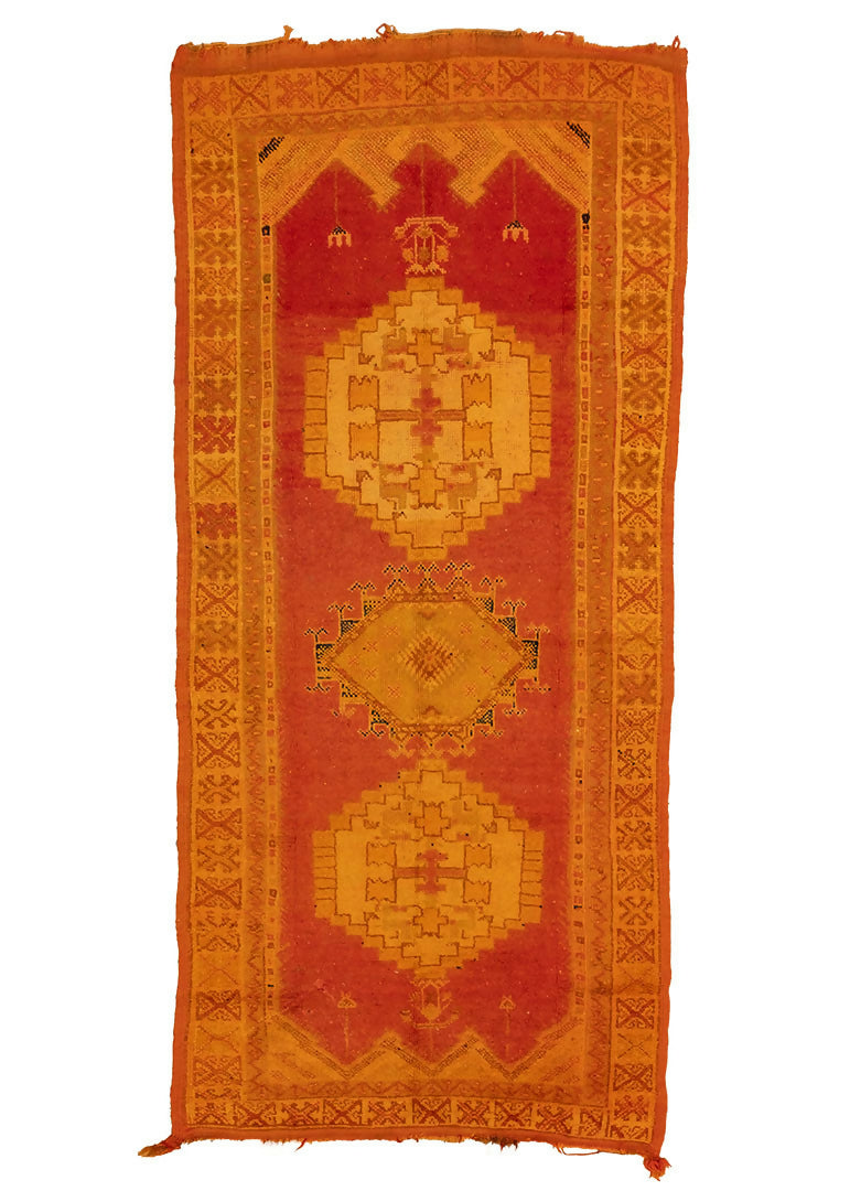 A vintage wool hand knotted rug with an open field design featuring geometric patterns in orange, red, and yellow shades, available  to buy on the-salon.com. SALON curates the finest , unique, handmade pieces from the interior industry's best makers and brands. Shop luxury furniture, lighting, rugs, art, antiques and vintage pieces and accessories from SALON interior designed rooms.