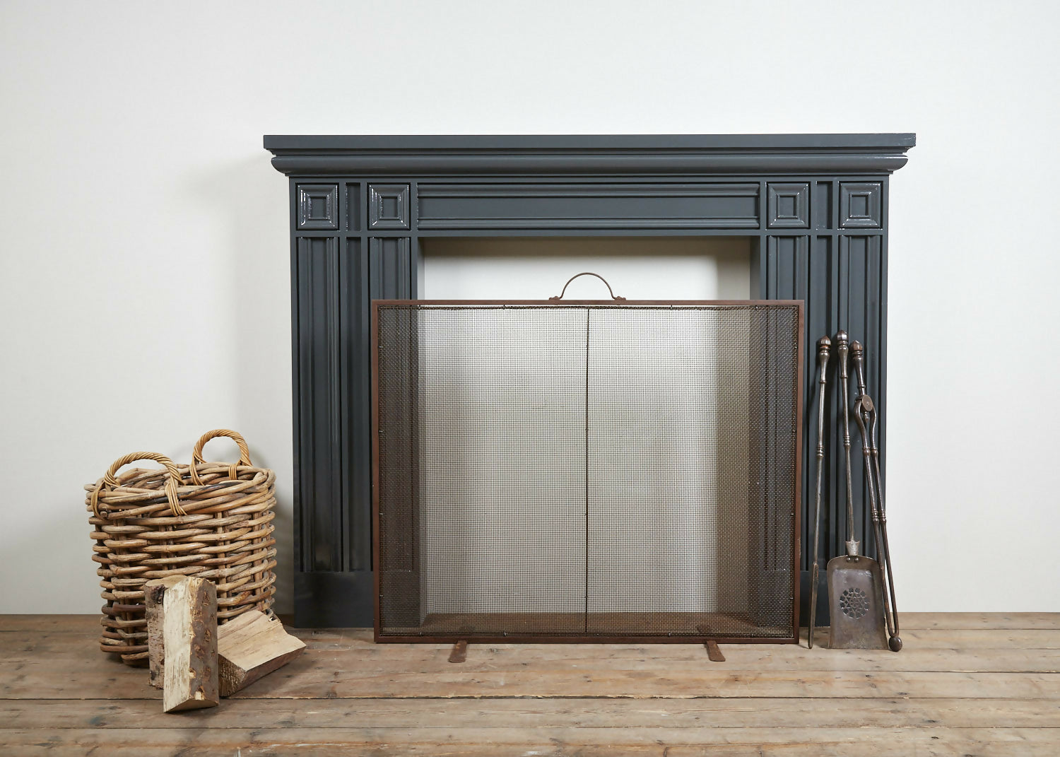 A neo-classical style fireplace made of redwood pine with a metal fire screen and tools in front, set against a white background,  available  to buy on the-salon.com. SALON curates the finest , unique, handmade pieces from the interior industry's best makers and brands. Shop luxury furniture, lighting, rugs, art, antiques and vintage pieces and accessories from SALON interior designed rooms.