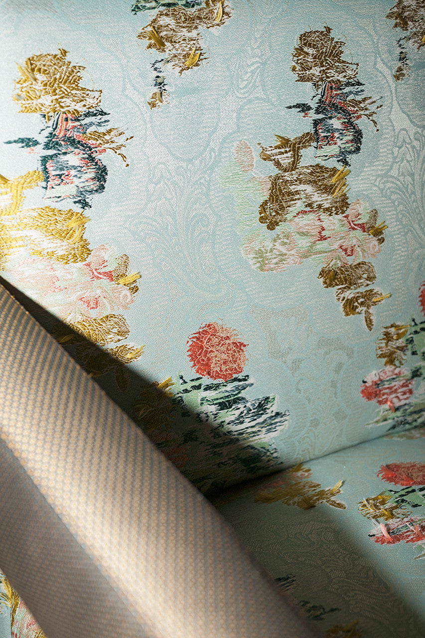 An image of a piece of fabric with yellow, blue and pink colours on a blue lace background, available  to buy on the-salon.com. SALON curates the finest , unique, handmade pieces from the interior industry's best makers and brands. Shop luxury furniture, lighting, rugs, art, antiques and vintage pieces and accessories from SALON interior designed rooms.