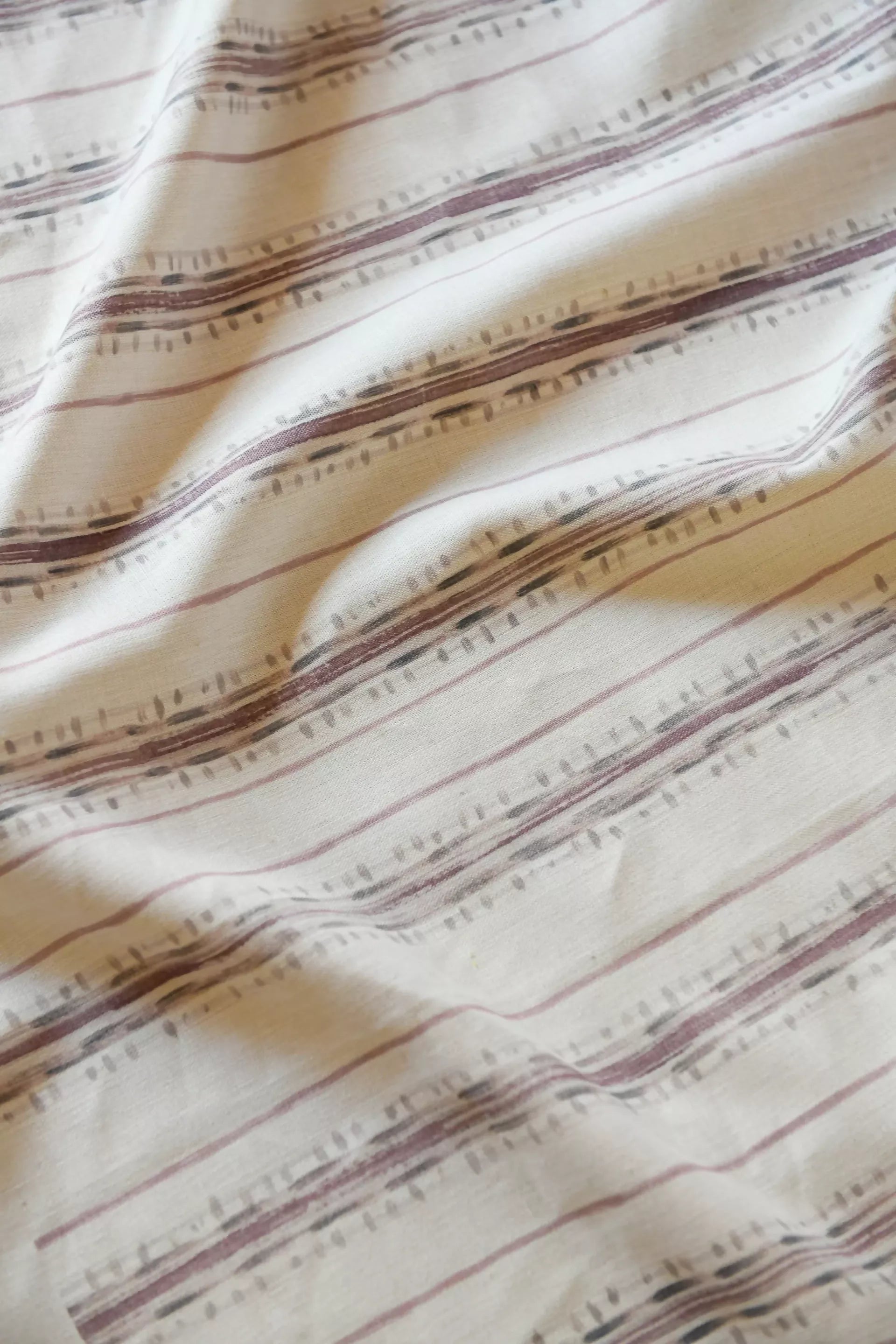 Close-up view of a textile fabric with a striped pattern featuring various shades of green and brown,available  to buy on the-salon.com. SALON curates the finest , unique, handmade pieces from the interior industry's best makers and brands. Shop luxury furniture, lighting, rugs, art, antiques and vintage pieces and accessories from SALON interior designed rooms
