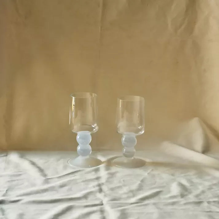 Two clear glasses on a white backdrop,  available  to buy on the-salon.com. SALON curates the finest , unique, handmade pieces from the interior industry's best makers and brands. Shop luxury furniture, lighting, rugs, art, antiques and vintage pieces and accessories from SALON interior designed rooms.