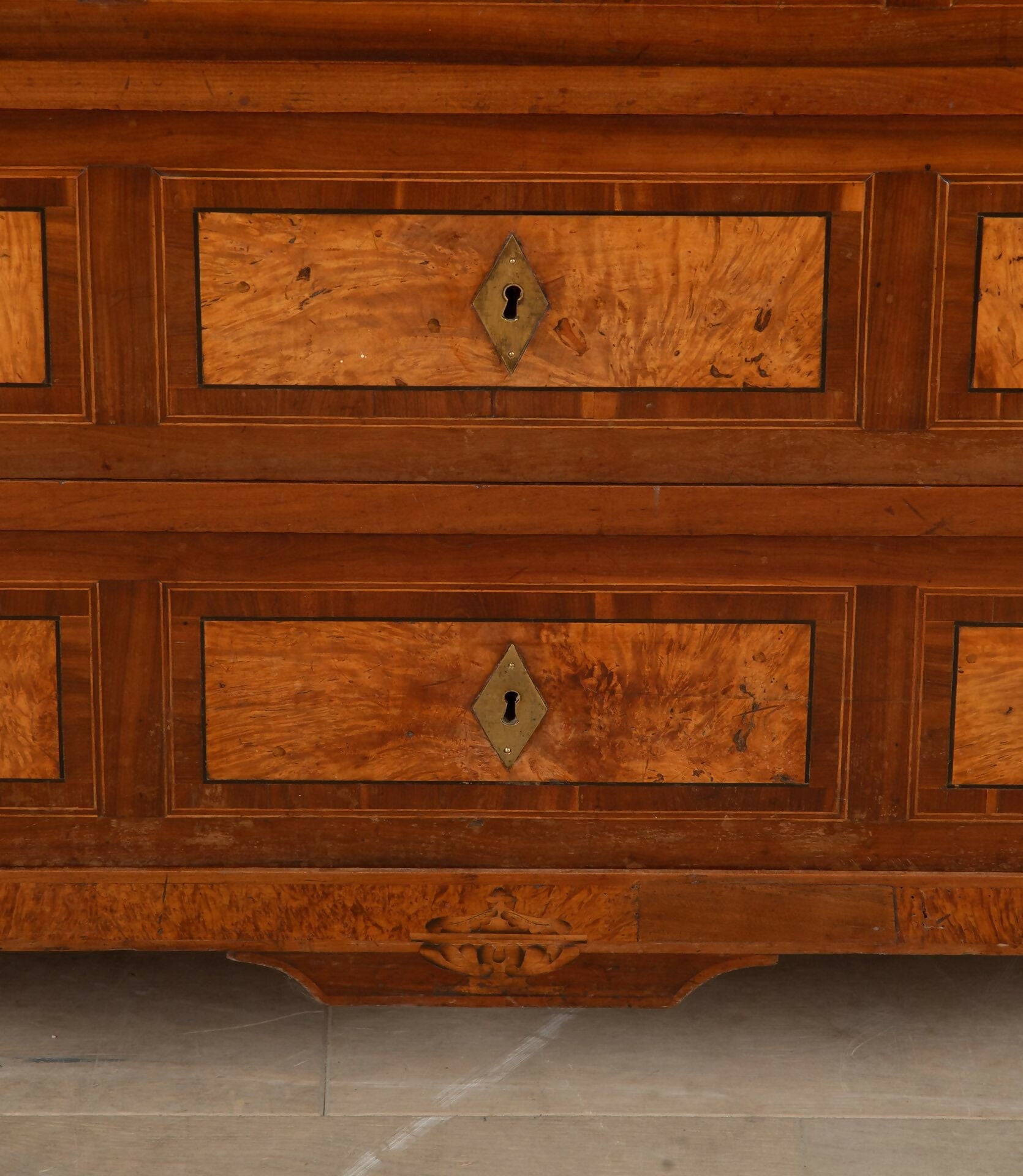 Close-up of a wooden dresser with intricate carvings and keyholes,  available  to buy on the-salon.com. SALON curates the finest , unique, handmade pieces from the interior industry's best makers and brands. Shop luxury furniture, lighting, rugs, art, antiques and vintage pieces and accessories from SALON interior designed rooms.