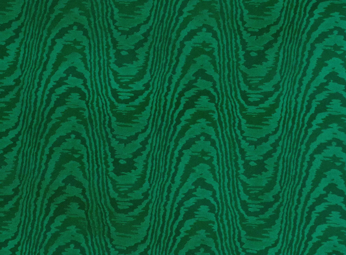 Close-up view of a green silk moiré fabric with a textured pattern,  available  to buy on the-salon.com. SALON curates the finest , unique, handmade pieces from the interior industry's best makers and brands. Shop luxury furniture, lighting, rugs, art, antiques and vintage pieces and accessories from SALON interior designed rooms.