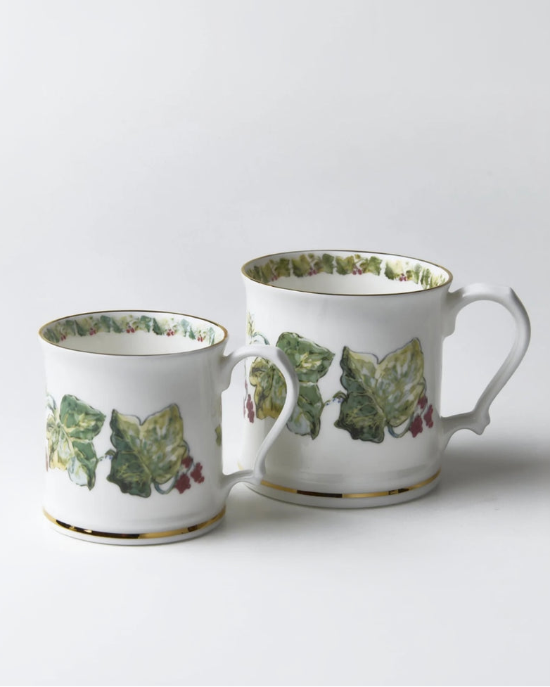 Two ceramic mugs with leaf pattern on a white background