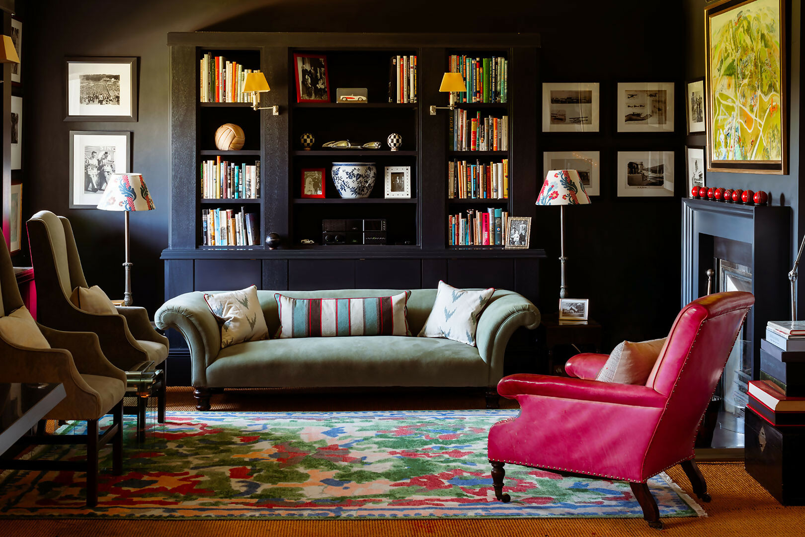 Living room with a bookshelf, sofa, and pink armchair,  available  to buy on the-salon.com. SALON curates the finest , unique, handmade pieces from the interior industry's best makers and brands. Shop luxury furniture, lighting, rugs, art, antiques and vintage pieces and accessories from SALON interior designed rooms.