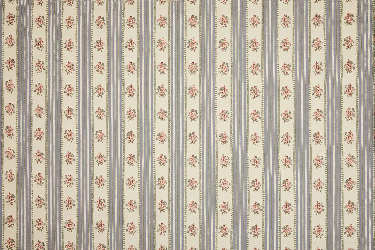 Close-up view of a fabric featuring a jacquard weave with a pattern of delicate embroidered floral motifs, stripes, and leaves in blue, green, and beige colours,  available  to buy on the-salon.com. SALON curates the finest , unique, handmade pieces from the interior industry's best makers and brands. Shop luxury furniture, lighting, rugs, art, antiques and vintage pieces and accessories from SALON interior designed rooms.