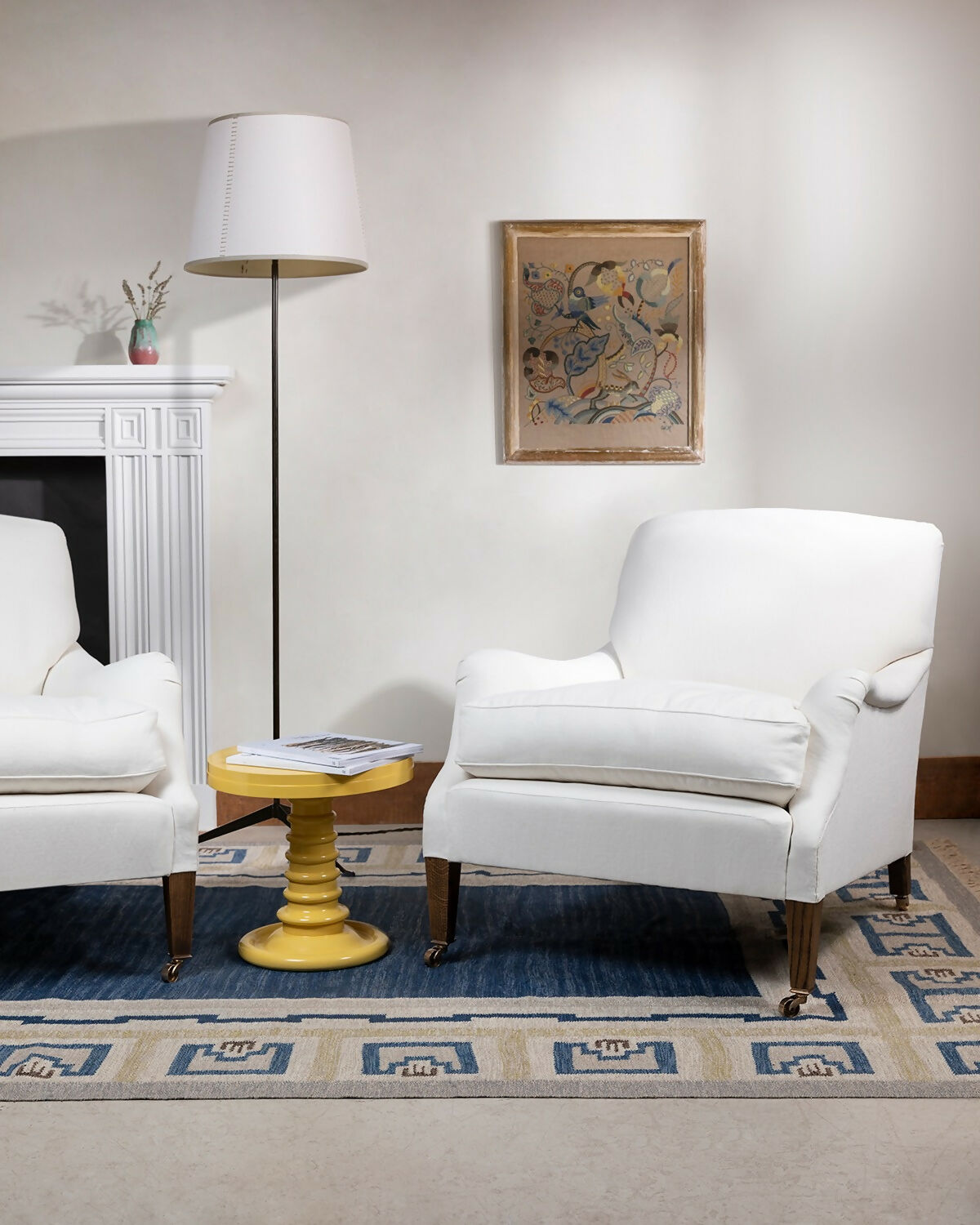 An image of a living room with two white chairs and a lamp with the white fireplace in the background against a white wall,  available  to buy on the-salon.com. SALON curates the finest , unique, handmade pieces from the interior industry's best makers and brands. Shop luxury furniture, lighting, rugs, art, antiques and vintage pieces and accessories from SALON interior designed r