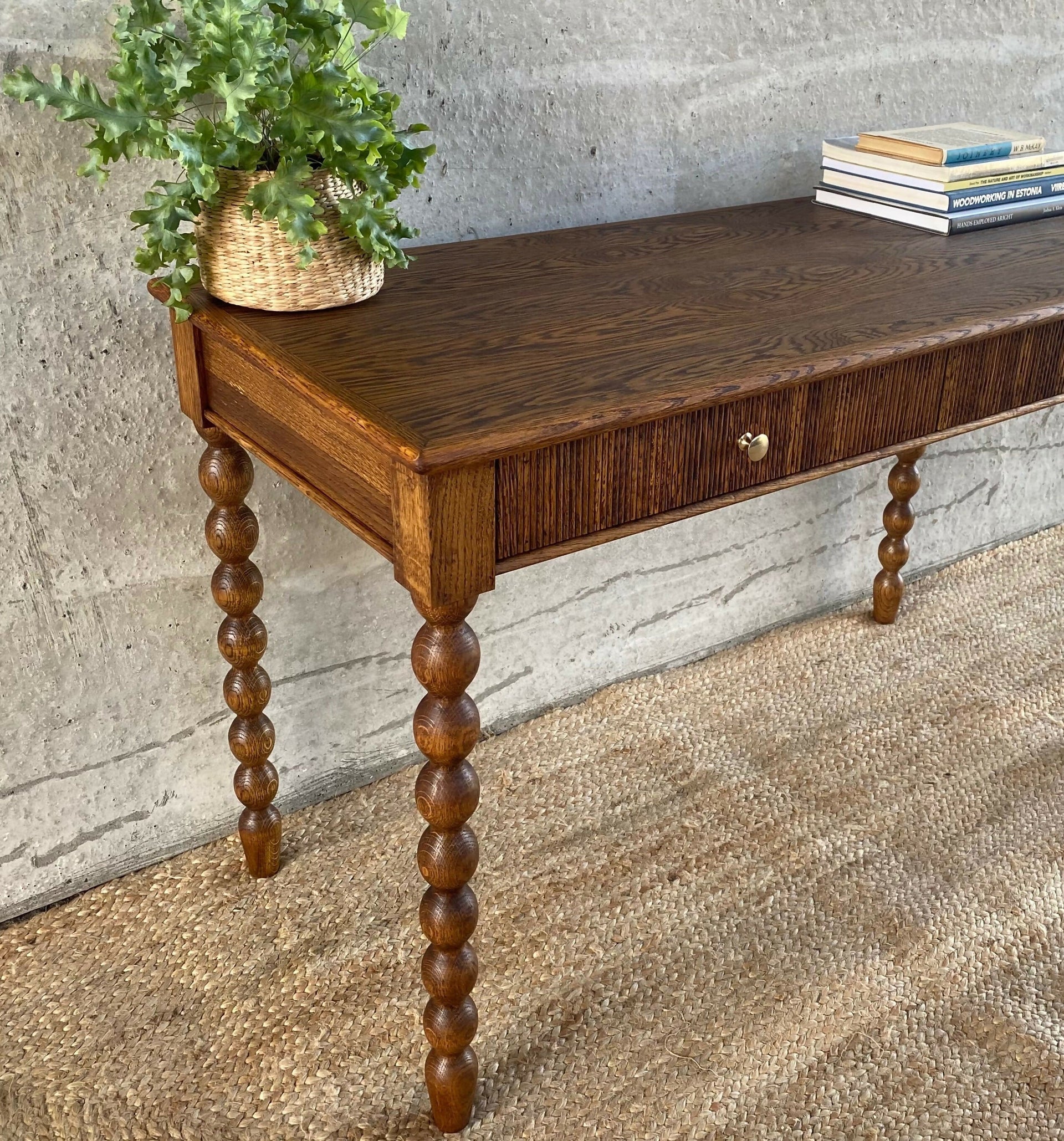 Wooden console table with spiral legs against a textured wall,available to buy from the-salon.com. SALON curates the finest unique handmade pieces from the interior industry's best makers and brands. Shop luxury furniture, lighting, rugs, art, antiques and vintage pieces and accessories from SALON interior designed rooms. 