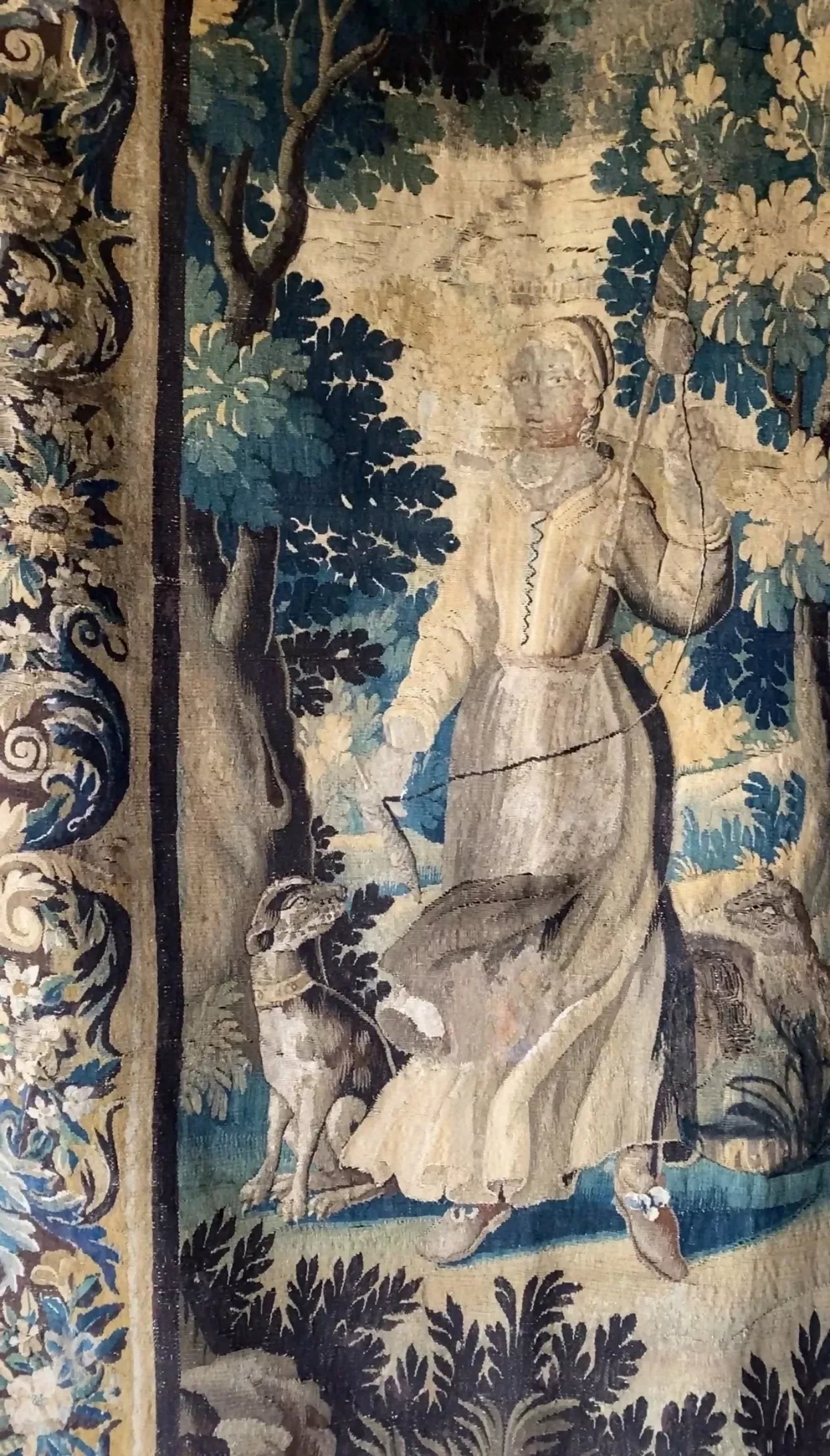 Close up of a decorative tapestry with a woman and forest design on a white brick wall,  available  to buy on the-salon.com. SALON curates the finest , unique, handmade pieces from the interior industry's best makers and brands. Shop luxury furniture, lighting, rugs, art, antiques and vintage pieces and accessories from SALON interior designed rooms.