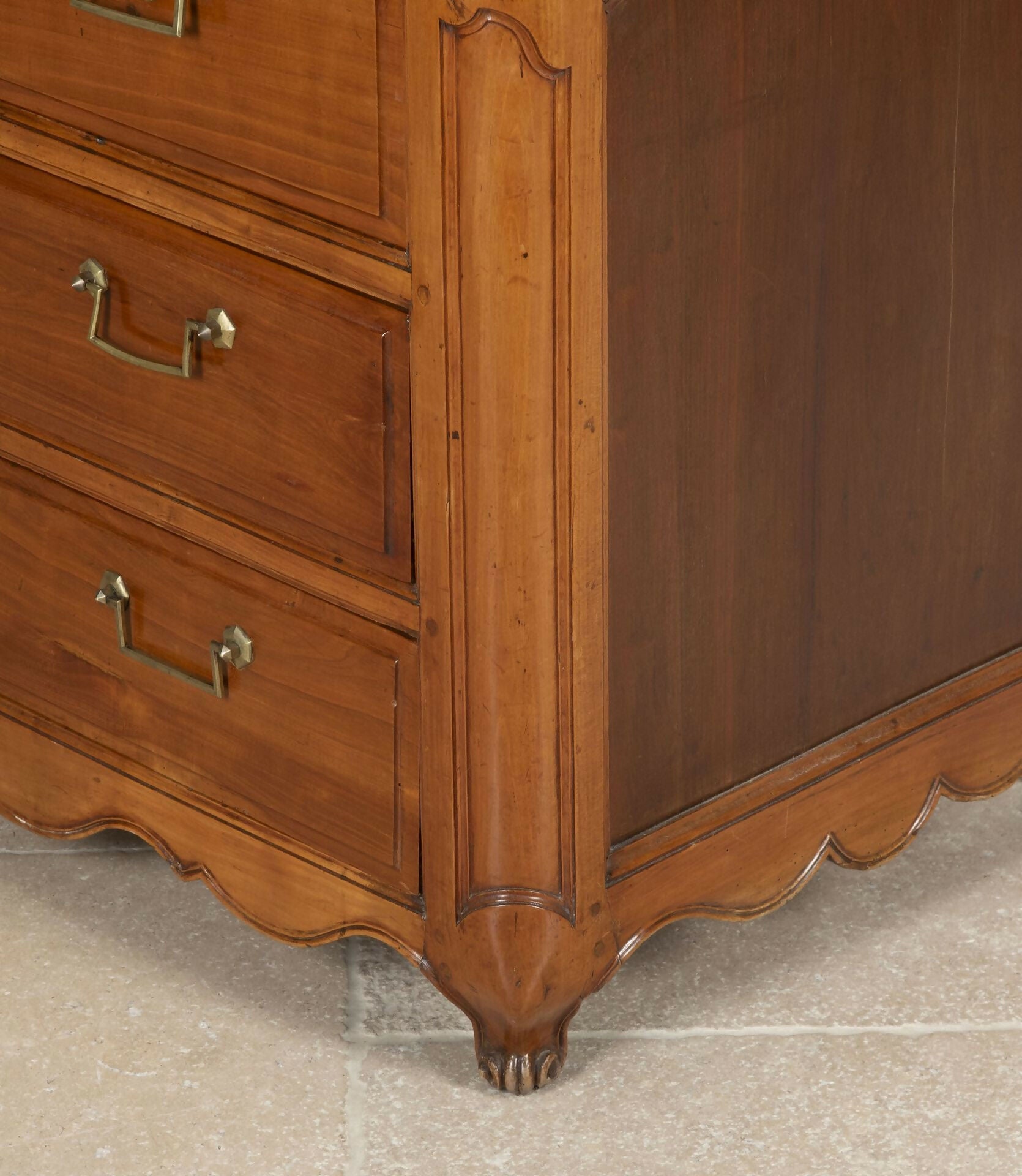 Close-up of a wooden dresser with curved design and brass handles,  available  to buy on the-salon.com. SALON curates the finest , unique, handmade pieces from the interior industry's best makers and brands. Shop luxury furniture, lighting, rugs, art, antiques and vintage pieces and accessories from SALON interior designed rooms.