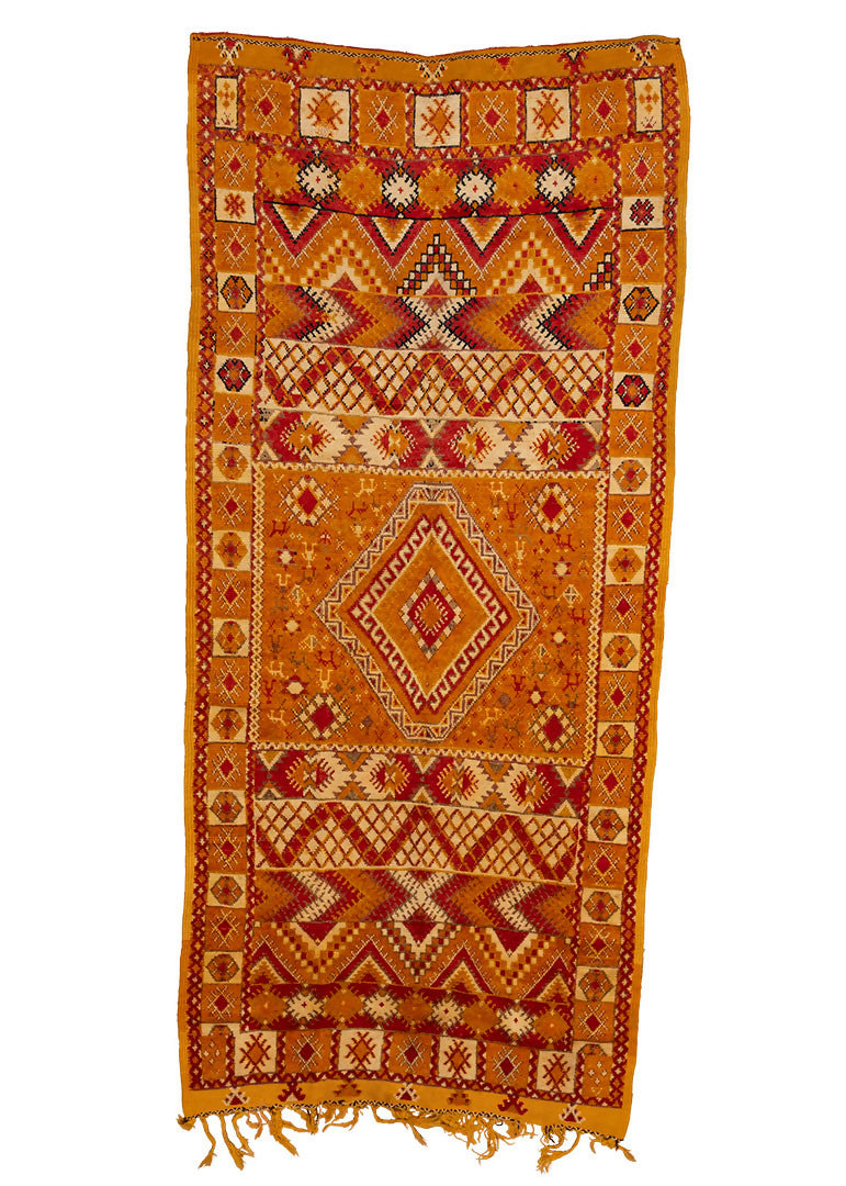 A vintage hand-knotted wool rug with geometric patterns and predominantly orange and red colors,  available  to buy on the-salon.com. SALON curates the finest , unique, handmade pieces from the interior industry's best makers and brands. Shop luxury furniture, lighting, rugs, art, antiques and vintage pieces and accessories from SALON interior designed rooms.