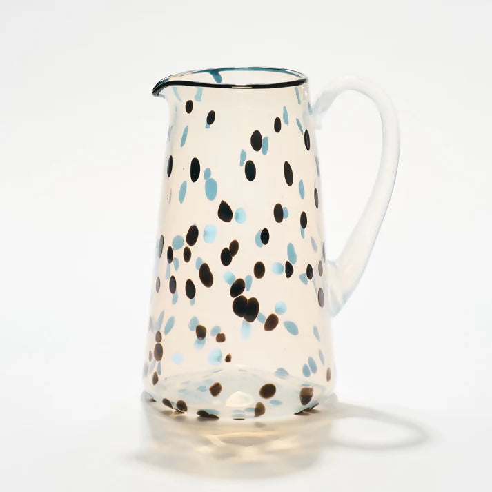A handblown glass jug with a dotted pattern in blue and brown on a white background,  available  to buy on the-salon.com. SALON curates the finest , unique, handmade pieces from the interior industry's best makers and brands. Shop luxury furniture, lighting, rugs, art, antiques and vintage pieces and accessories from SALON interior designed rooms.