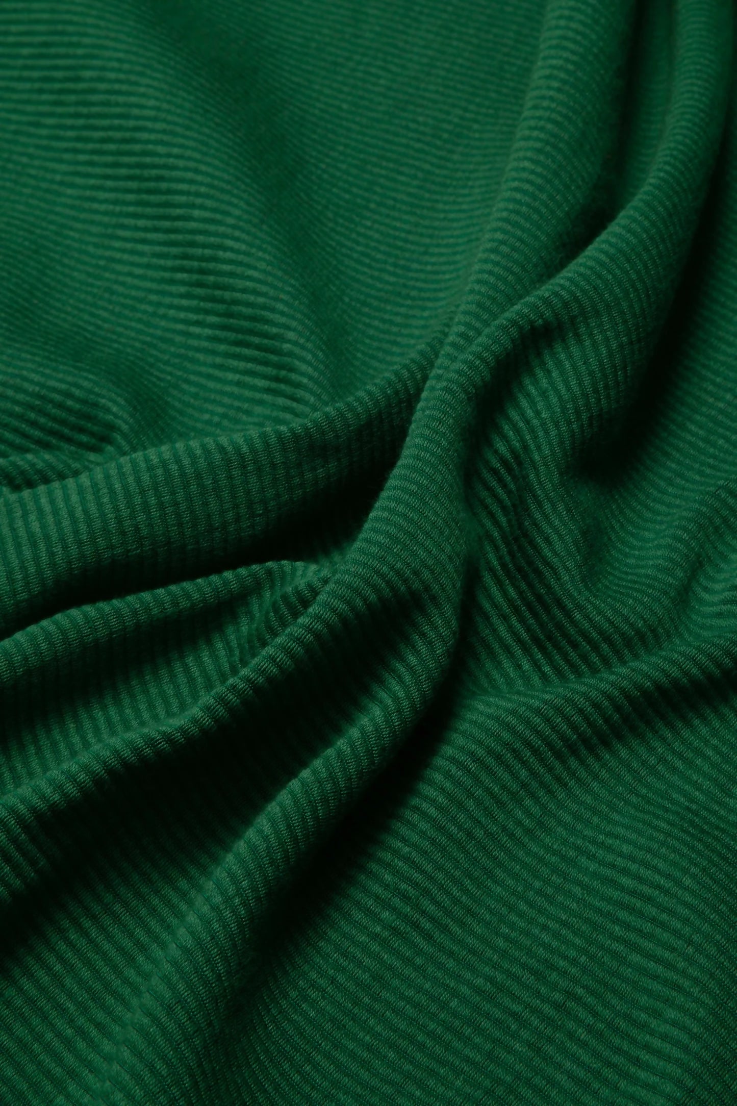 A close-up image of green repp fabric, displaying its texture and solid colour,  available  to buy on the-salon.com. SALON curates the finest , unique, handmade pieces from the interior industry's best makers and brands. Shop luxury furniture, lighting, rugs, art, antiques and vintage pieces and accessories from SALON interior designed rooms.
