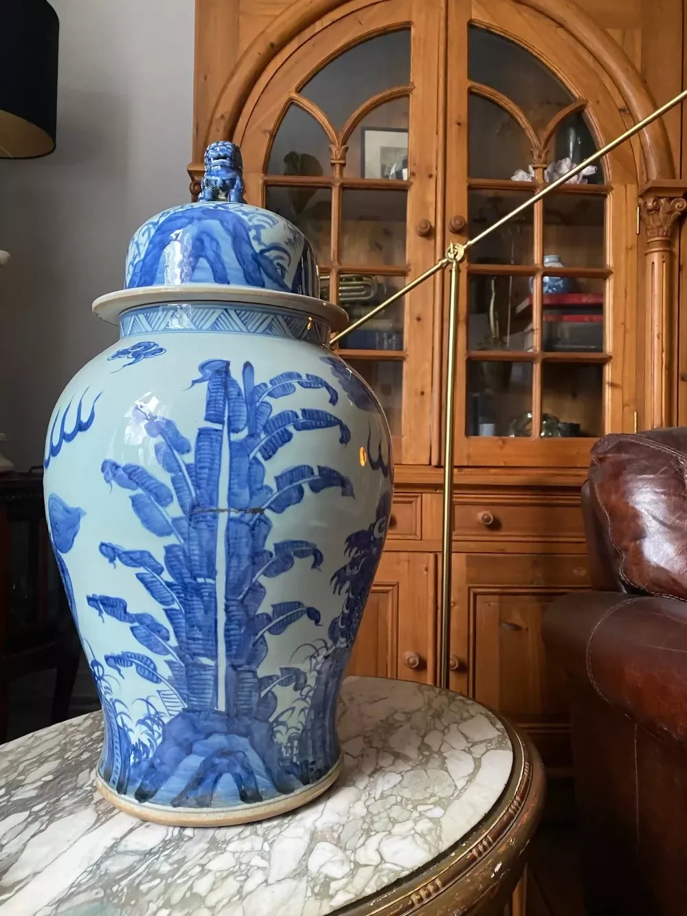 Blue and white decorative vase on a marble table with wooden cabinet in the background,available to buy from the-salon.com. SALON curates the finest unique handmade pieces from the interior industry's best makers and brands. Shop luxury furniture, lighting, rugs, art, antiques and vintage pieces and accessories from SALON interior designed rooms.