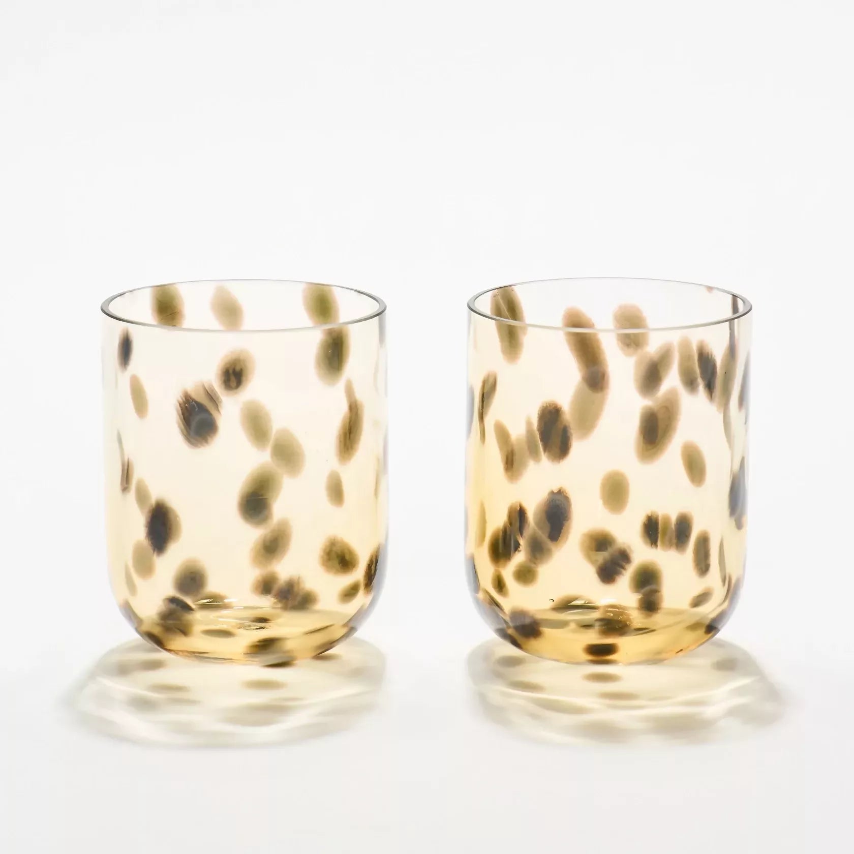 Two glass tumblers with a leopard print pattern on a white background- available  to buy on the-salon.com. SALON curates the finest , unique, handmade pieces from the interior industry's best makers and brands. Shop luxury furniture, lighting, rugs, art, antiques and vintage pieces and accessories from SALON interior designed rooms.