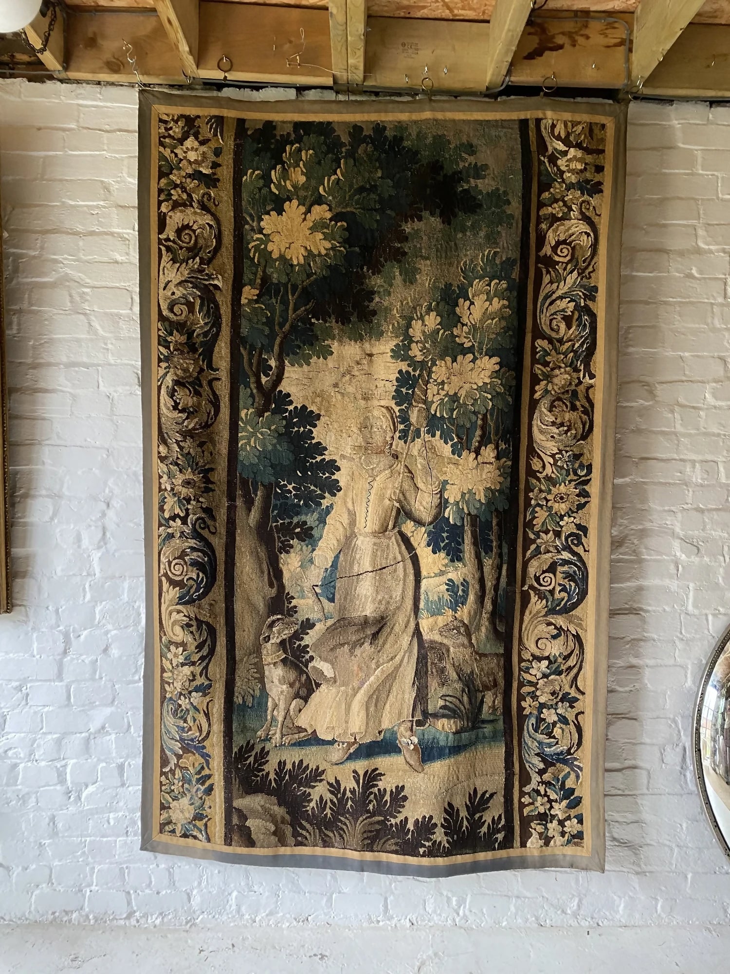 Decorative tapestry with a woman and a forest design on a white brick wall,  available  to buy on the-salon.com. SALON curates the finest , unique, handmade pieces from the interior industry's best makers and brands. Shop luxury furniture, lighting, rugs, art, antiques and vintage pieces and accessories from SALON interior designed rooms.