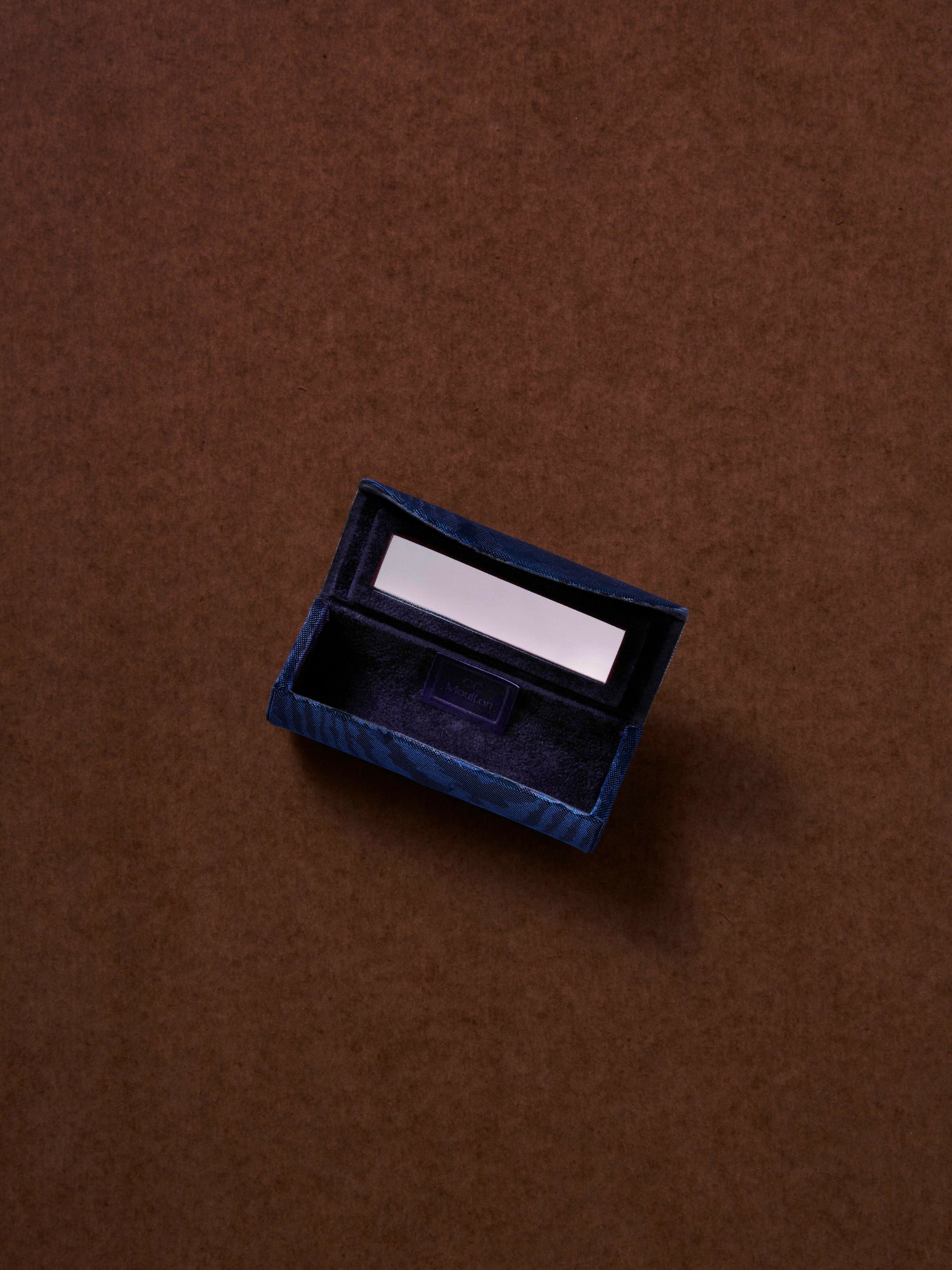 Small blue box with a silver item on a brown background,  available  to buy on the-salon.com. SALON curates the finest , unique, handmade pieces from the interior industry's best makers and brands. Shop luxury furniture, lighting, rugs, art, antiques and vintage pieces and accessories from SALON interior designed rooms.