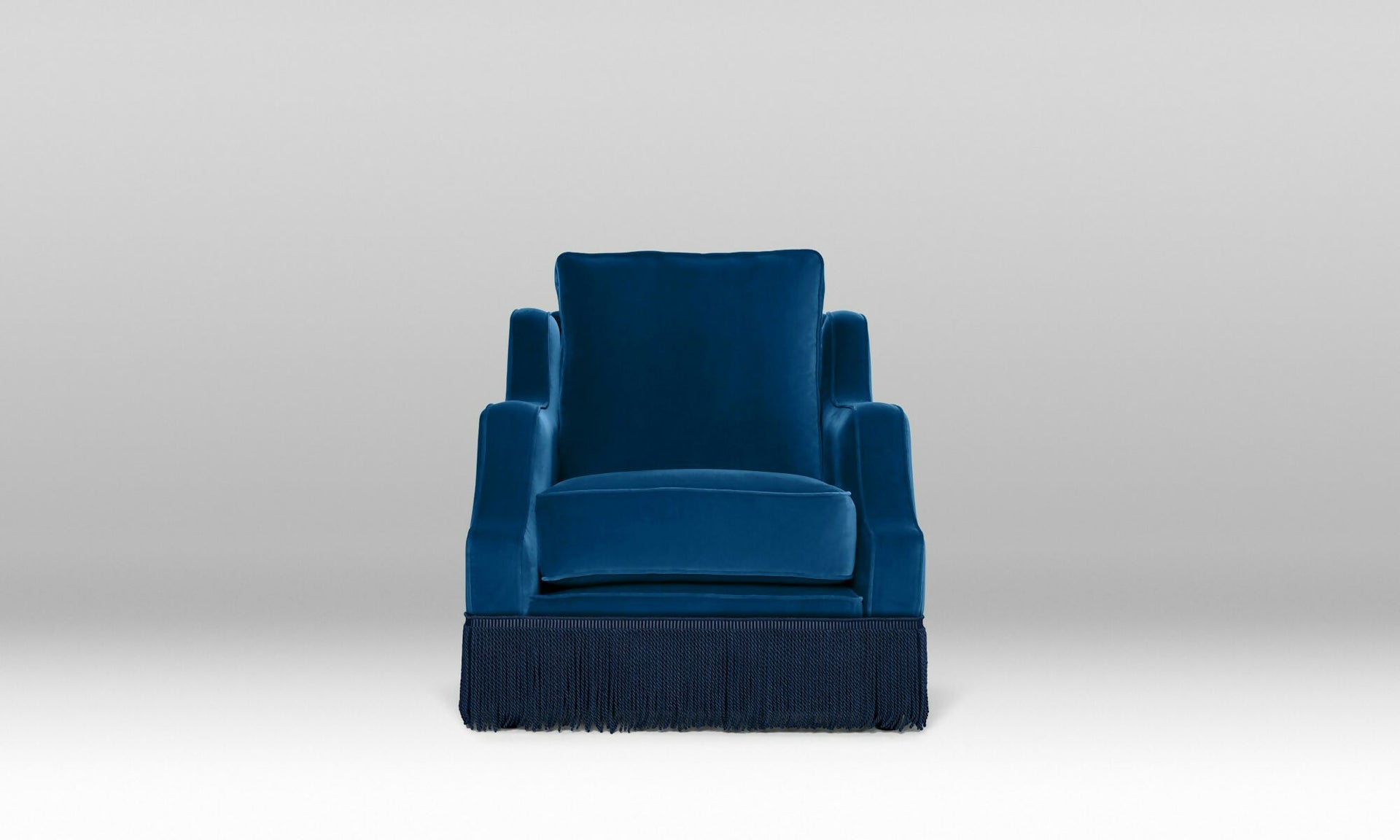 An ornate upholstered Atlanta chair with velvet fabric and tasseled fringe, designed by Orior, available  to buy on the-salon.com. SALON curates the finest , unique, handmade pieces from the interior industry's best makers and brands. Shop luxury furniture, lighting, rugs, art, antiques and vintage pieces and accessories from SALON interior designed rooms.