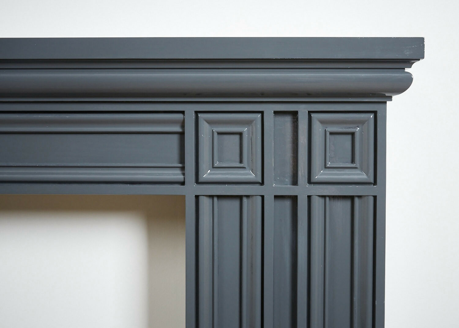 A close up of the ornate sculpture and handcrafted wood on the fireplace against a white wall,  available  to buy on the-salon.com. SALON curates the finest , unique, handmade pieces from the interior industry's best makers and brands. Shop luxury furniture, lighting, rugs, art, antiques and vintage pieces and accessories from SALON interior designed rooms.