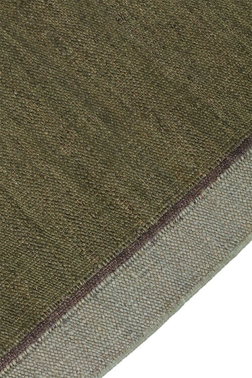 Close-up view of a hand-woven dhurrie rug with a plain texture and a visible border,  available  to buy on the-salon.com. SALON curates the finest , unique, handmade pieces from the interior industry's best makers and brands. Shop luxury furniture, lighting, rugs, art, antiques and vintage pieces and accessories from SALON interior designed rooms.