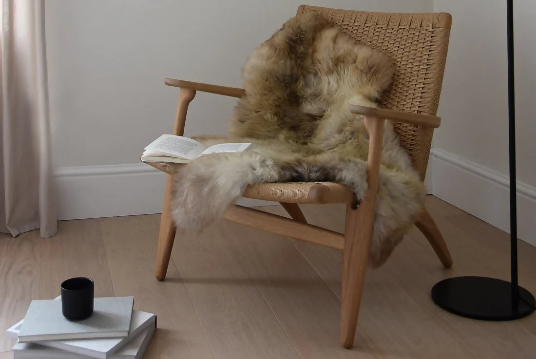 Brown sheepskin rug, covering a wicker chair. The rug, available to buy from the-salon.com. SALON curates the finest unique handmade pieces from the interior industry's best makers and brands. Shop luxury furniture, lighting, rugs, art, antiques and vintage pieces and accessories from SALON interior designed rooms. 