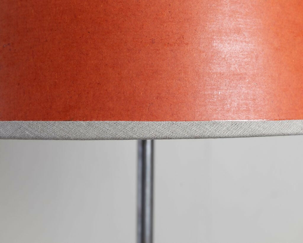 A tapered lampshade with a hand-stitched design, in Pompeian Buff colour, displayed on a stand against a neutral background, available  to buy on the-salon.com. SALON curates the finest , unique, handmade pieces from the interior industry's best makers and brands. Shop luxury furniture, lighting, rugs, art, antiques and vintage pieces and accessories from SALON interior designed rooms.