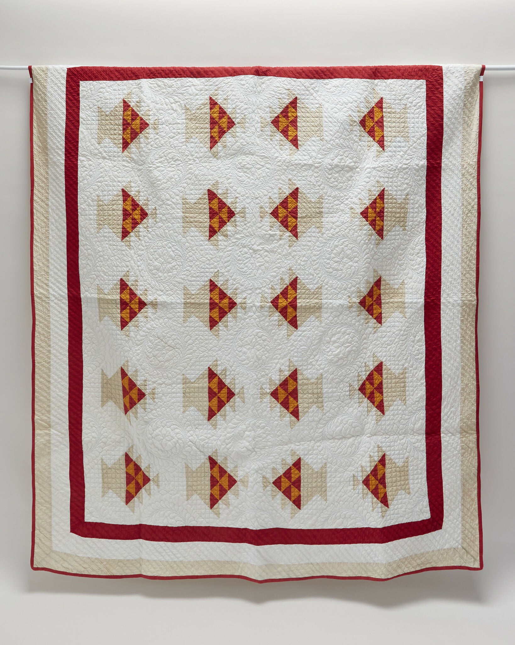 Quilt with red and orange geometric pattern on a white background,  available  to buy on the-salon.com. SALON curates the finest , unique, handmade pieces from the interior industry's best makers and brands. Shop luxury furniture, lighting, rugs, art, antiques and vintage pieces and accessories from SALON interior designed rooms.