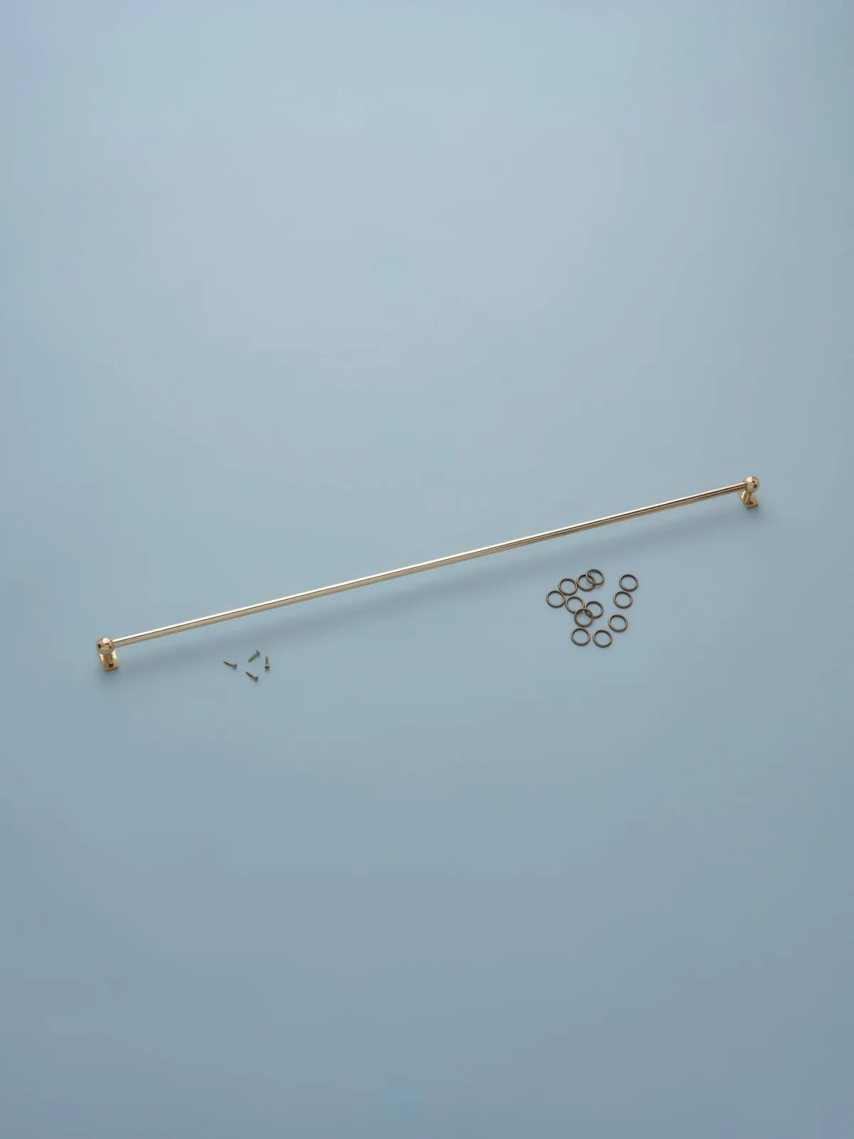 Gold-colored rod with small components on a light blue background,  available  to buy on the-salon.com. SALON curates the finest , unique, handmade pieces from the interior industry's best makers and brands. Shop luxury furniture, lighting, rugs, art, antiques and vintage pieces and accessories from SALON interior designed rooms.