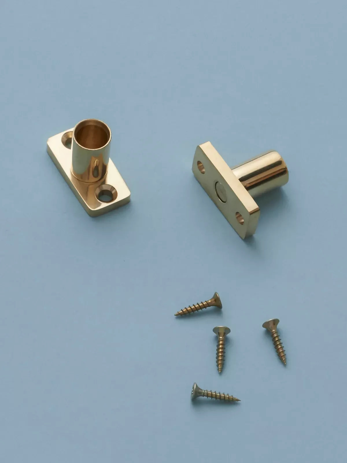Two gold metal brackets with screws on a blue background,  available  to buy on the-salon.com. SALON curates the finest , unique, handmade pieces from the interior industry's best makers and brands. Shop luxury furniture, lighting, rugs, art, antiques and vintage pieces and accessories from SALON interior designed rooms.