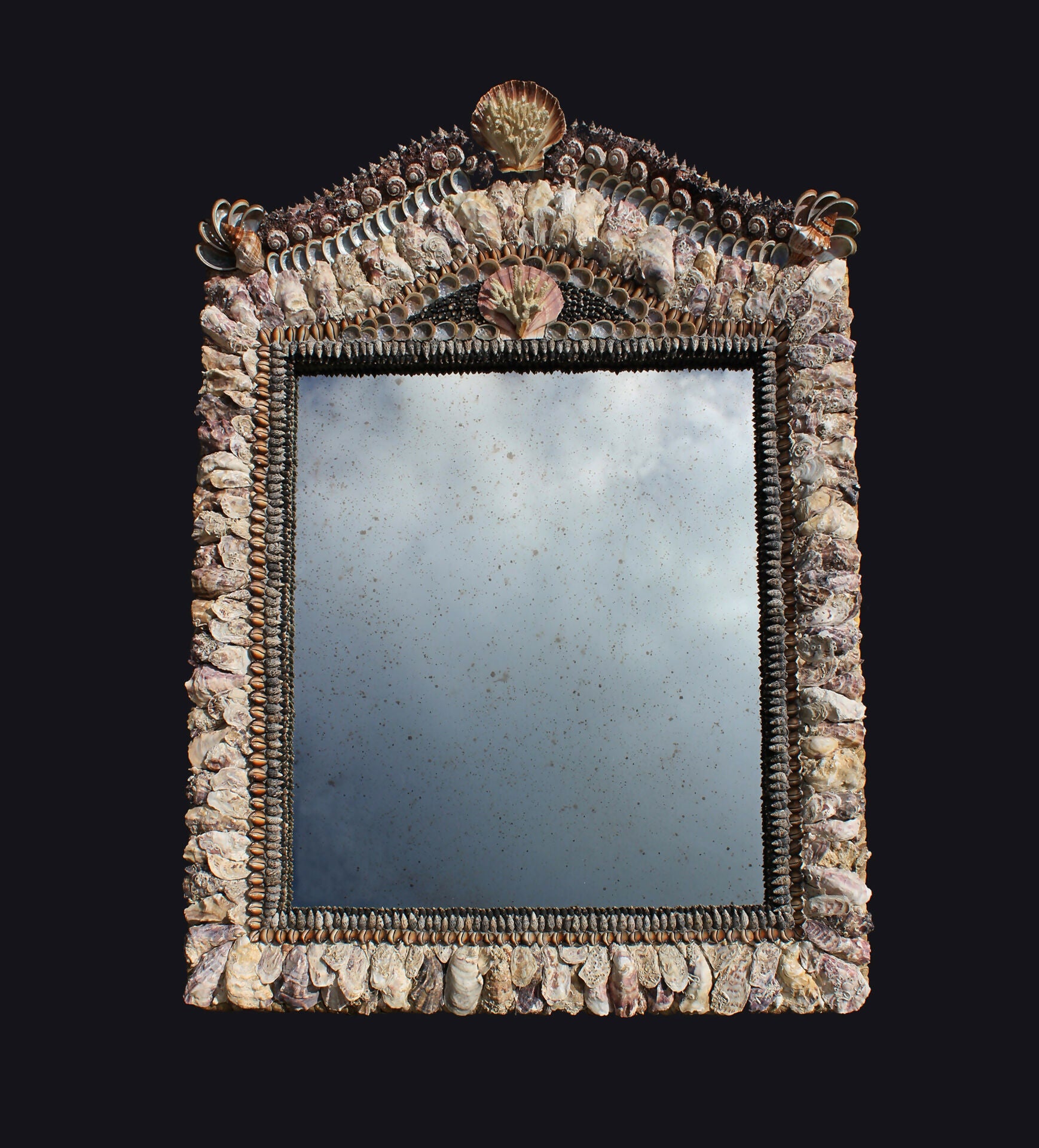 A decorative mirror with a frame made up of natural and off-white shells, featuring a central oval motif,  available  to buy on the-salon.com. SALON curates the finest , unique, handmade pieces from the interior industry's best makers and brands. Shop luxury furniture, lighting, rugs, art, antiques and vintage pieces and accessories from SALON interior designed rooms.