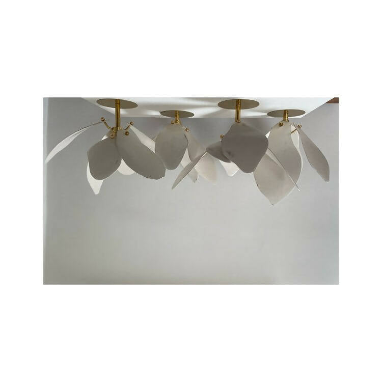 A close-up image of a white magnolia flower pendant light with a brass fitting and a gold-topped SES lamp,  available  to buy on the-salon.com. SALON curates the finest , unique, handmade pieces from the interior industry's best makers and brands. Shop luxury furniture, lighting, rugs, art, antiques and vintage pieces and accessories from SALON interior designed rooms.