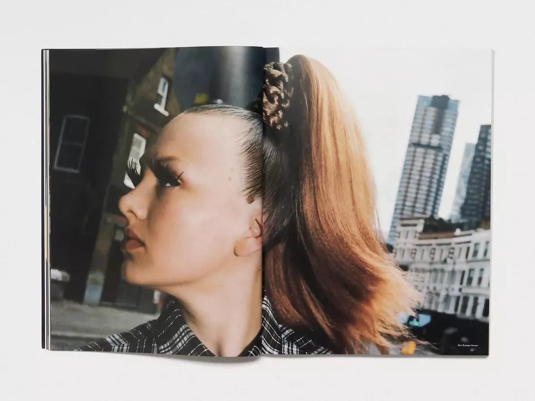 An open book, pages to a large image of a woman wearing extremely long false lashes and her hair slicked back and in a very high ponytail looking toward the side , available  to buy on the-salon.com. SALON curates the finest , unique, handmade pieces from the interior industry's best makers and brands. Shop luxury furniture, lighting, rugs, art, antiques and vintage pieces and accessories from SALON interior designed rooms.
