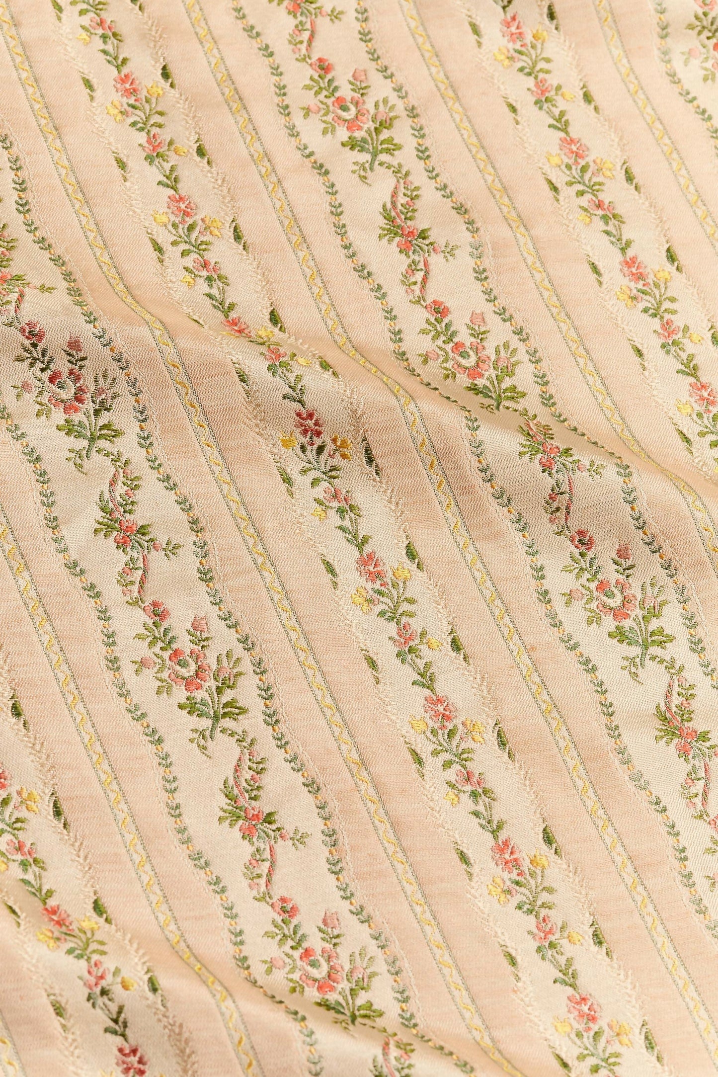 Close-up of Spitalfields stripe blush fabric with a jacquard weave showcasing floral motifs and silk edges,  available  to buy on the-salon.com. SALON curates the finest , unique, handmade pieces from the interior industry's best makers and brands. Shop luxury furniture, lighting, rugs, art, antiques and vintage pieces and accessories from SALON interior designed rooms.